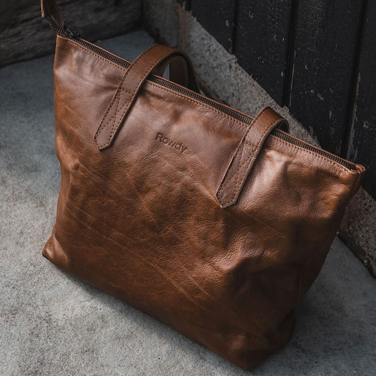 A Rowdy leather tote bag, its full-grain leather creased and darkened with use