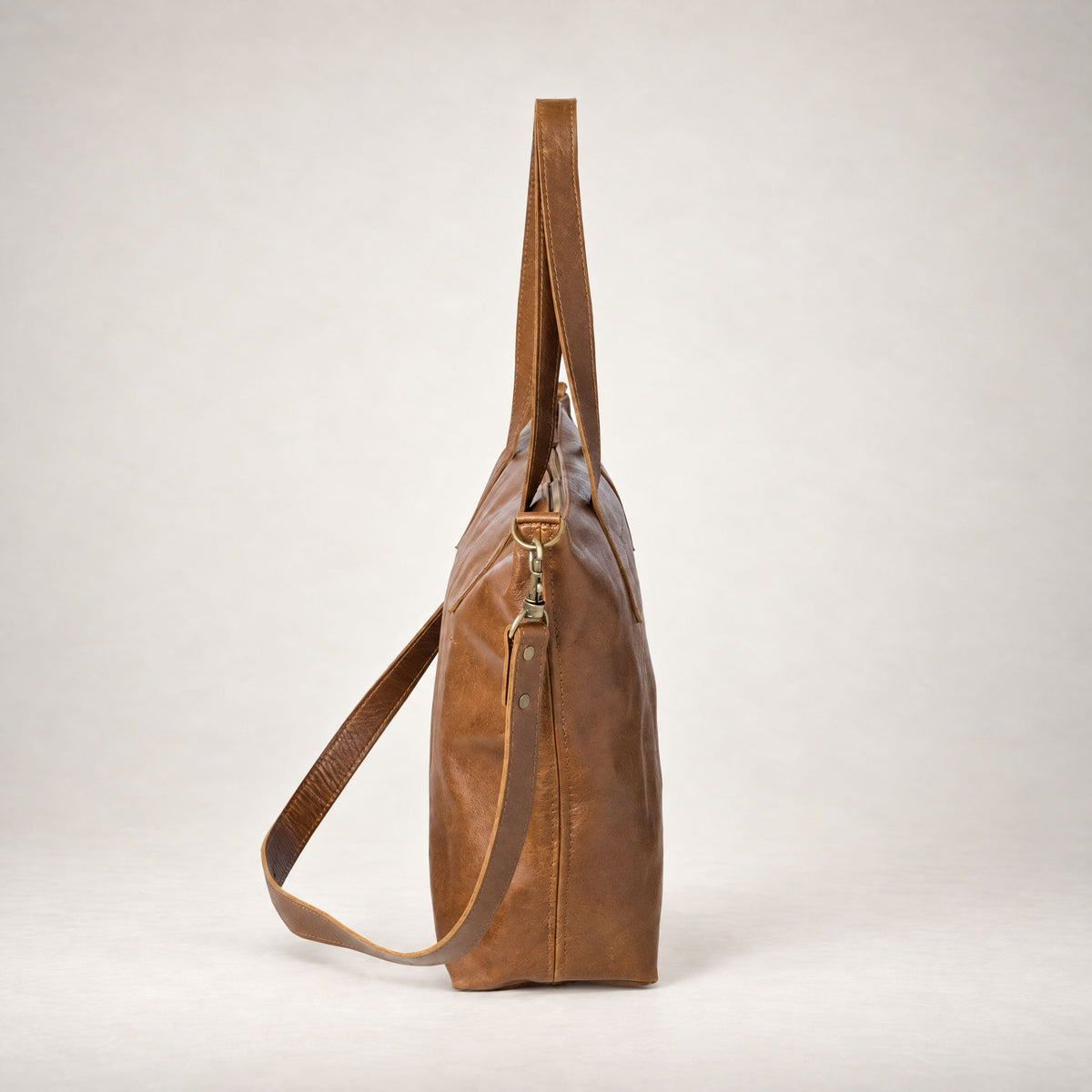 Rowdy Leather Crossbody Bag in Cedar (smooth aniline leather), side view with the strap clipped on