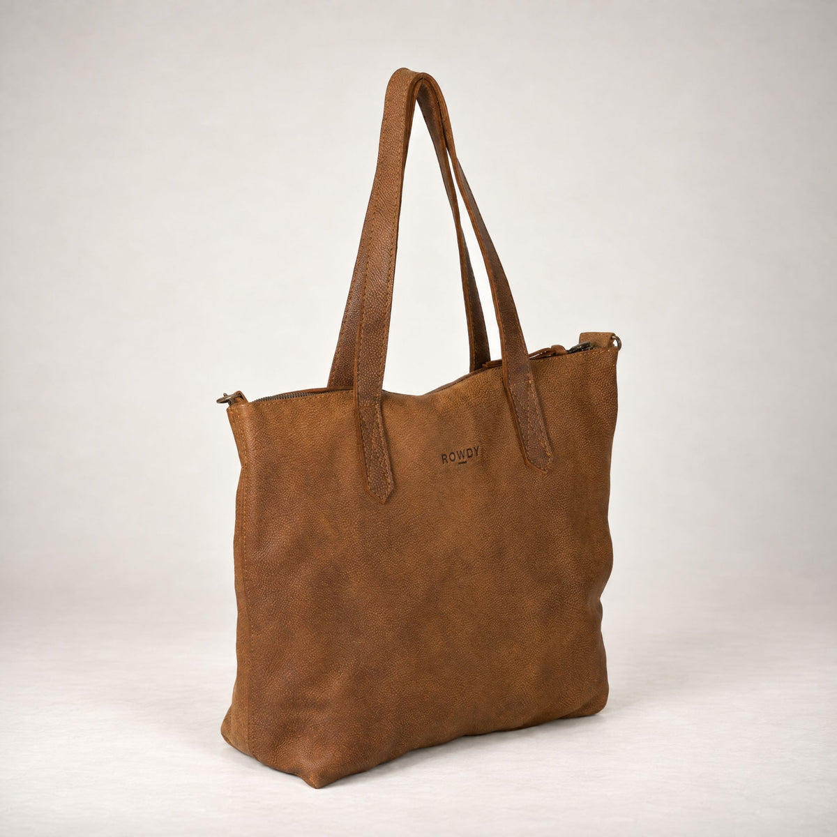 Rowdy Leather Crossbody Bag in Mountain (nubuck leather), three-quarter view showing the zip top and grab handles