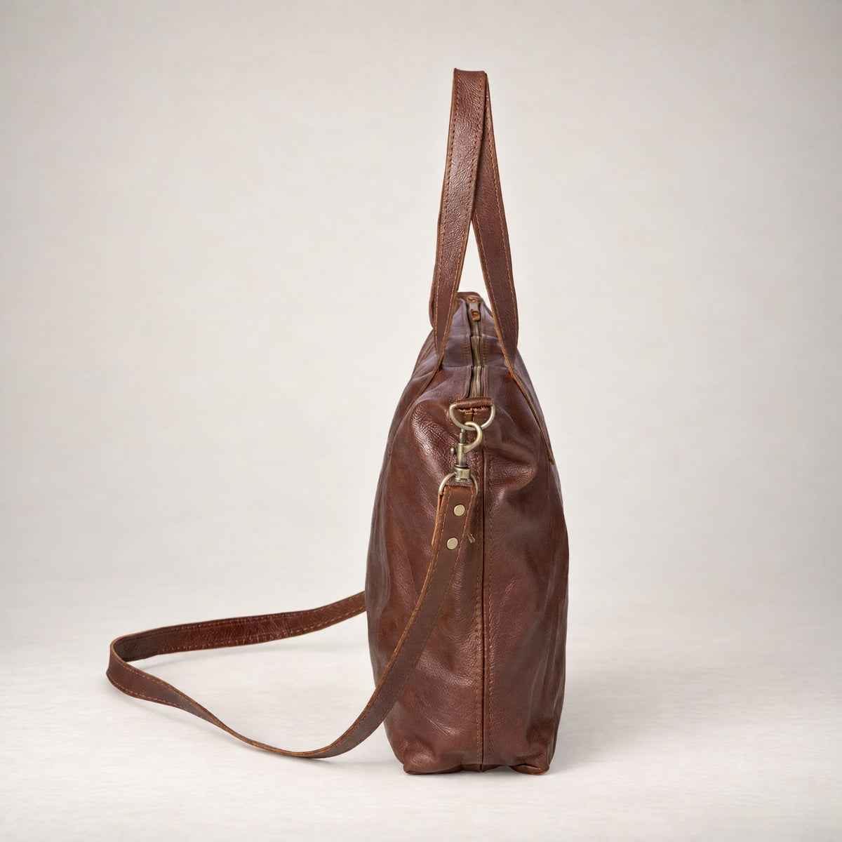 Rowdy Leather Crossbody Bag in Maple (smooth aniline leather), side view with the strap clipped on