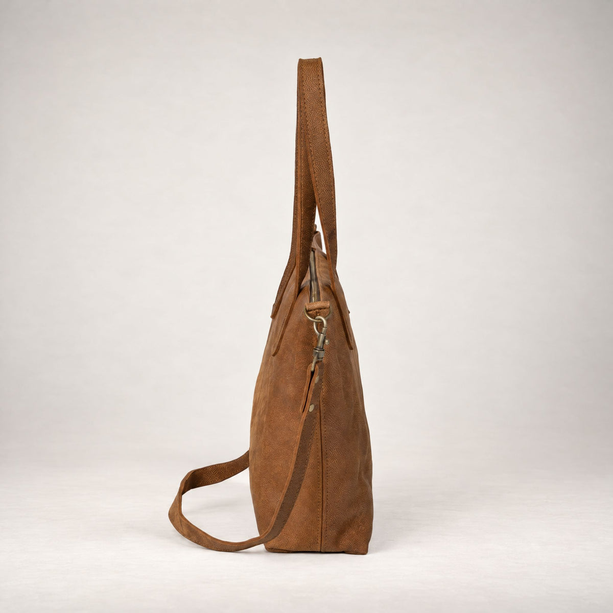 Rowdy Leather Crossbody Bag in Mountain (nubuck leather), side view with the strap clipped on