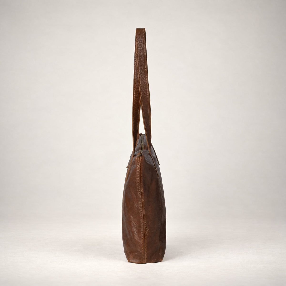 Rowdy Leather Tote Bag in Cedar (smooth aniline leather), side view showing its slim 12 cm depth