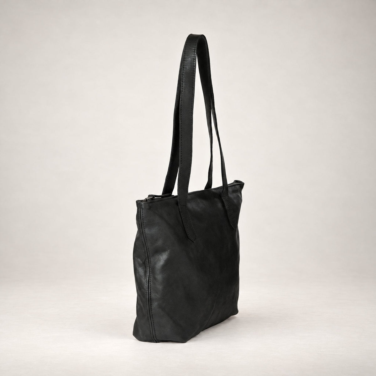 Rowdy Leather Tote Bag in Charcoal (textured aniline leather), three-quarter view showing the zip top