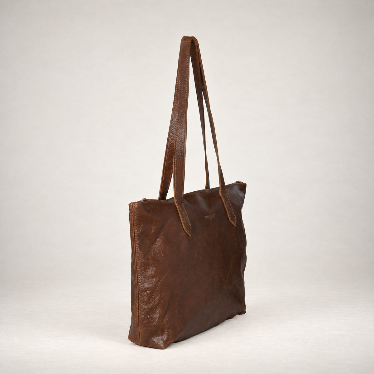 Rowdy Leather Tote Bag in Cedar (smooth aniline leather), three-quarter view showing the zip top
