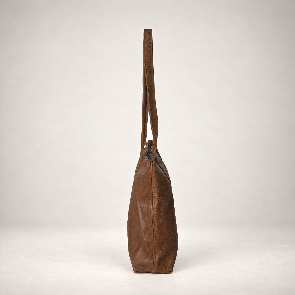 Rowdy Leather Tote Bag in Mountain (velvety nubuck leather), side view showing its slim 12 cm depth