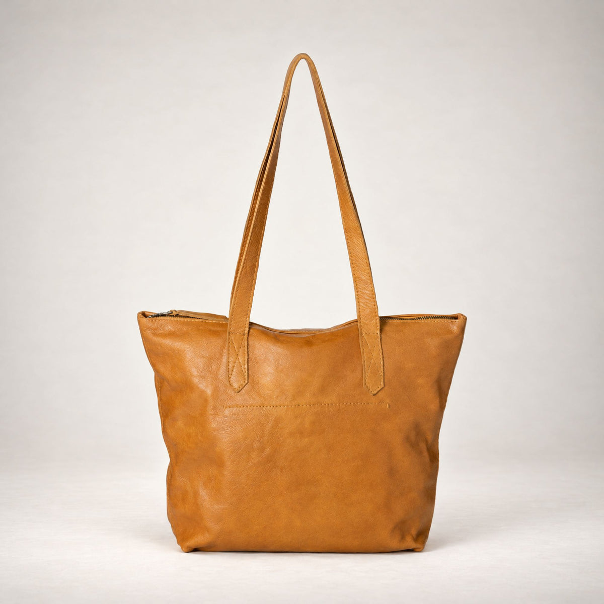Rowdy Leather Tote Bag in Amber (smooth aniline leather), back view showing the stitched slip pocket