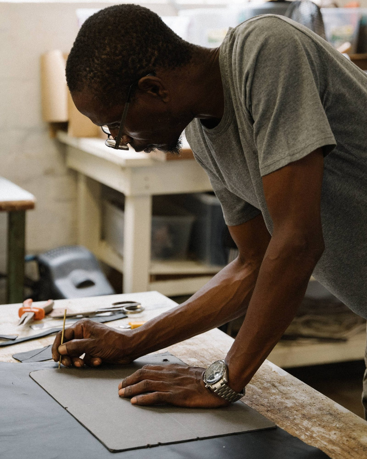 George, one of our makers, marking out a bag pattern on leather by hand
