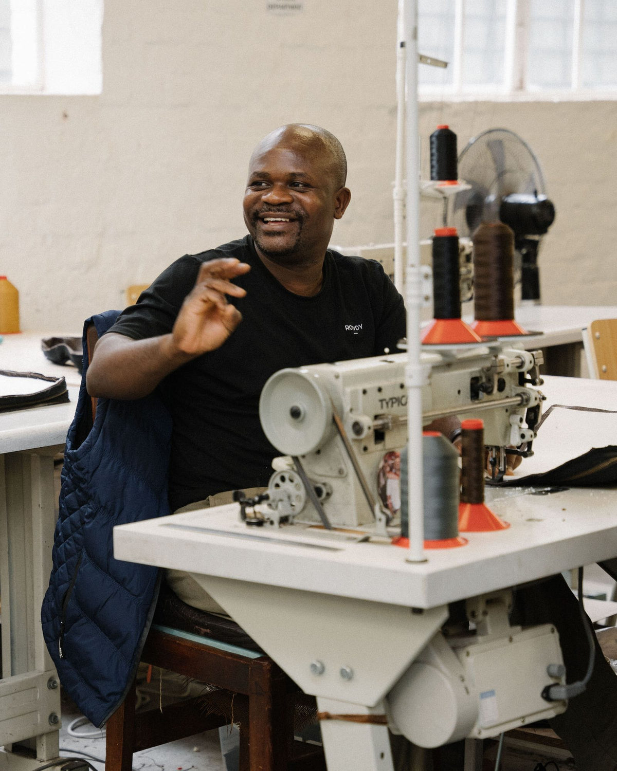 A smiling Rowdy maker at his sewing machine