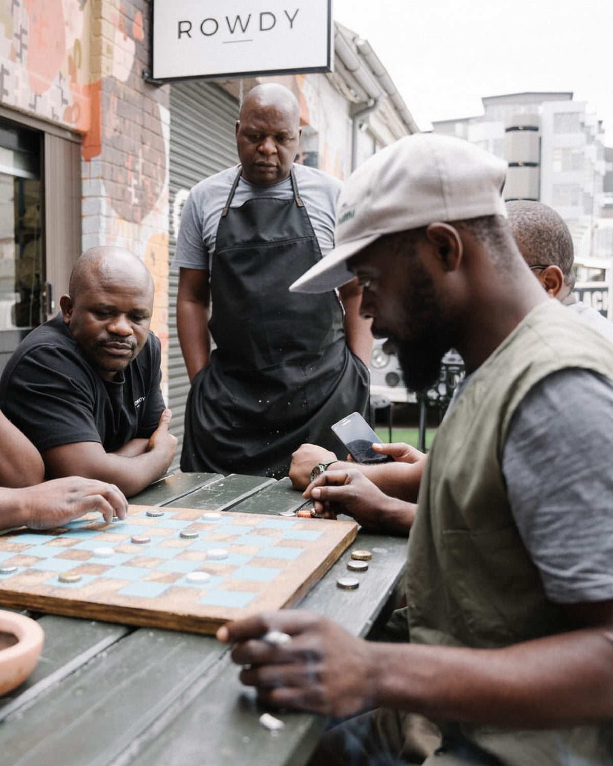 Rowdy makers playing draughts outside the workshop on a break