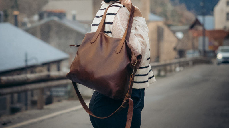 Woman in a Breton stripe jumper wearing the Rowdy Leather Crossbody Bag on her shoulder on a bridge